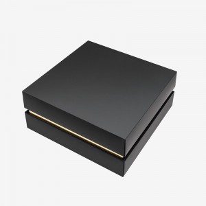 Boscaí saincheaptha a dhréachtaíonn cairtchlár bronntanais dubh athchúrsáilte a phacáil le ribín